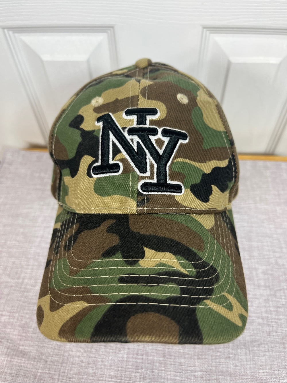 Camo colored NY hat with velcro strap in back